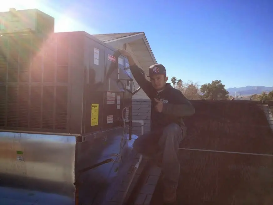 HVAC technician performing AC Tune-Up on a rooftop unit in Lilburn